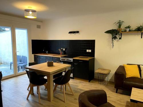 une cuisine et un salon avec une table et un canapé dans l'établissement La baumiere 6 personnes, à Cholet