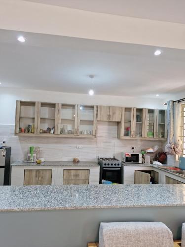 a kitchen with white cabinets and a granite counter top at Jade luxury apartments Diani in Mombasa