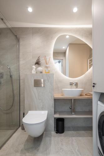 a bathroom with a toilet and a sink and a mirror at LightSummerPalanga in Palanga