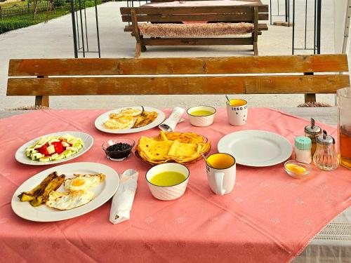 a table with plates of food on a red table cloth at Ekoo katun Jezerca in Vusanje