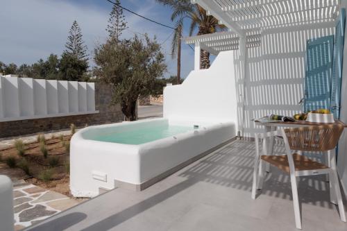 a tub on a patio with a table and a chair at Agia Anna Living in Agia Anna Naxos