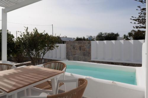 a patio with a table and chairs next to a swimming pool at Agia Anna Living in Agia Anna Naxos