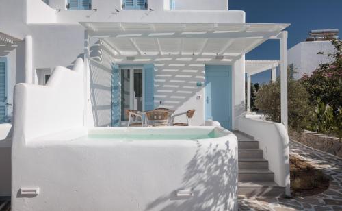 a white house with a balcony with a table and chairs at Agia Anna Living in Agia Anna Naxos