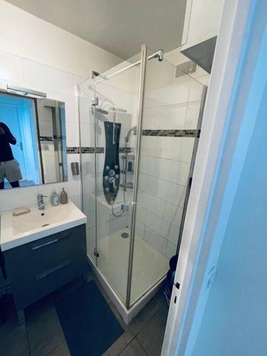 une salle de bain avec une douche en verre et un lavabo dans l'établissement 8N Apartment group near Paris, à Bondy