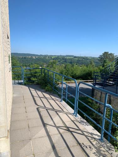 a walkway with a blue railing on the side of a building at Durbuy Dream in Durbuy