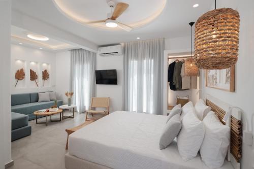 a bedroom with a white bed and a living room at Agia Anna Living in Agia Anna Naxos