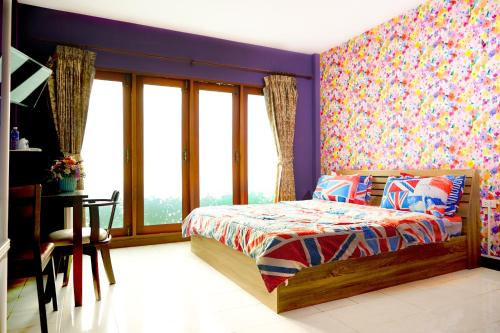 a bedroom with a bed and a wall of windows at Baan Dara Resort in Sara Buri