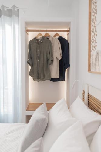 a bedroom with a bed and a clothes rack at Agia Anna Living in Agia Anna Naxos