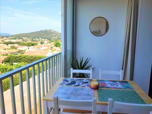a table and chairs on a balcony with a view at Appartement T2 neuf vue mer en bord de mer in Six-Fours-les-Plages