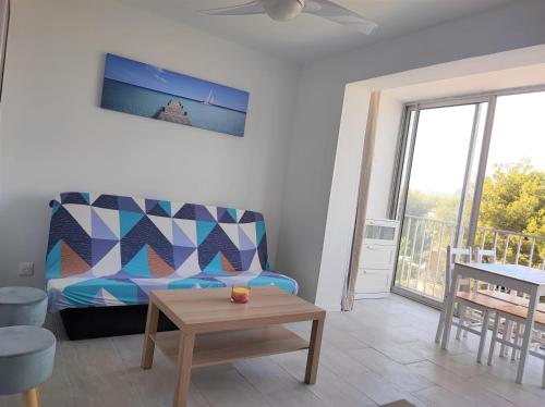 a living room with a couch and a table at Appartement T2 neuf vue mer en bord de mer in Six-Fours-les-Plages