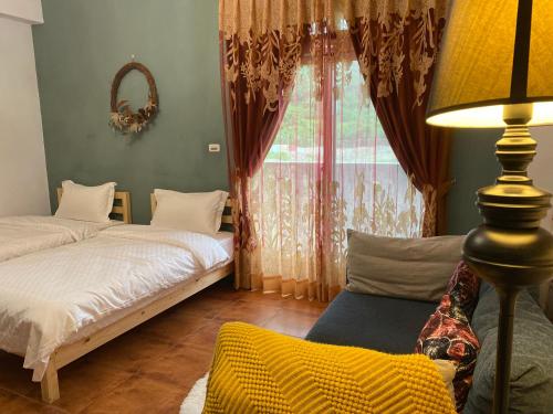 a bedroom with two beds and a lamp and a window at Sea Princess B&B in Fengbin
