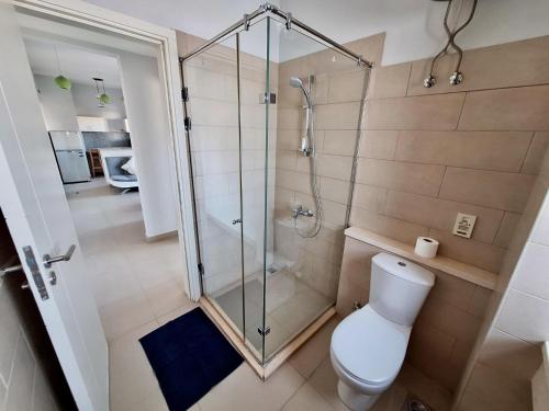a bathroom with a toilet and a glass shower at El Gouna Waterside E 1-Bedroom Ground Floor Sleeps 4 Persons in Hurghada