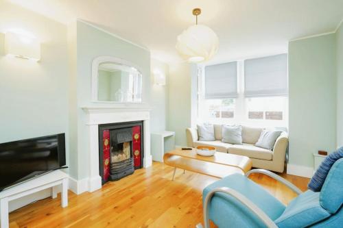 a living room with a couch and a fireplace at Stunning, newly renovated, Edwardian townhouse in Oxford