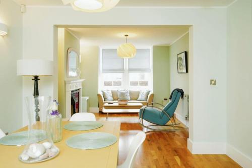 a living room with a table and chairs and a couch at Stunning, newly renovated, Edwardian townhouse in Oxford