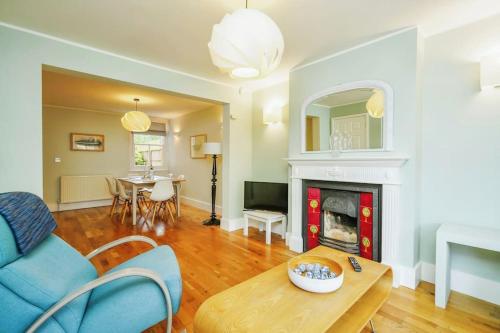 a living room with a blue couch and a fireplace at Stunning, newly renovated, Edwardian townhouse in Oxford