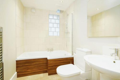 a bathroom with a tub and a toilet and a sink at Stunning, newly renovated, Edwardian townhouse in Oxford