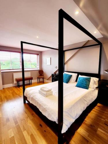a bedroom with a large bed with a black frame at Stunning, newly renovated, Edwardian townhouse in Oxford