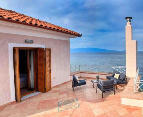 a patio with chairs and a view of the ocean at Goddesses Villa 1 in Nies in Soúrpi