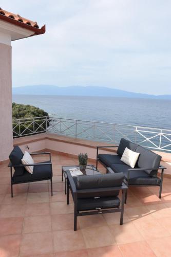 a patio with two couches and a table and the ocean at Goddesses Villa 1 in Nies in Soúrpi