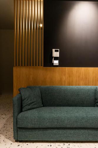 a green couch in a room with a wall at Residenza San Longino in Mantova