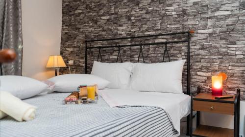 a bedroom with a bed and a brick wall at Villa of byron in Kastrákion