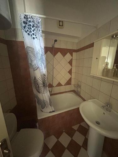 a bathroom with a tub and a toilet and a sink at Theros Kalamitsa Apartment in Kavála