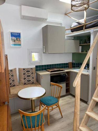 une cuisine avec une table, deux chaises et une table dans l'établissement maison ville proche plage prophete corniche, à Marseille