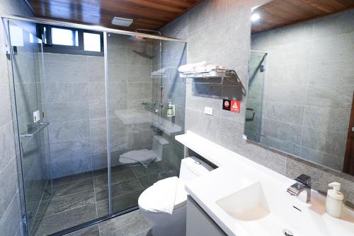 a bathroom with a shower and a toilet and a sink at Zhaohong homestay in Yuchi