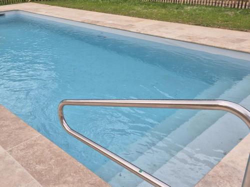 - une piscine avec un rail métallique dans l'eau dans l'établissement LE PRESBYTERE, à Prats-du-Périgord