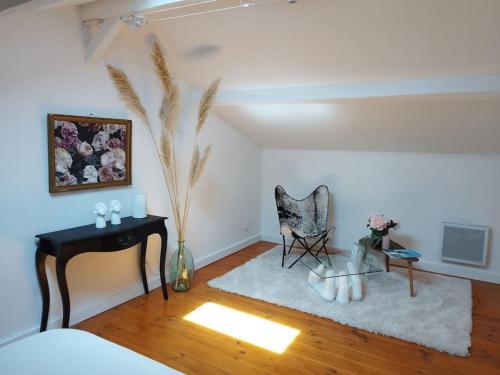 ein Wohnzimmer mit einem Tisch und einem Stuhl in der Unterkunft Appartement proche aéroport & indret in Bouguenais