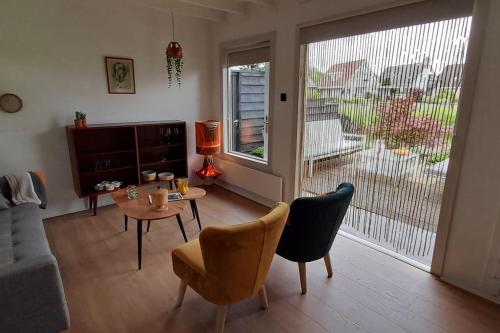a living room with a table and chairs at Tuinhuis Vijverzicht in Leeuwarden