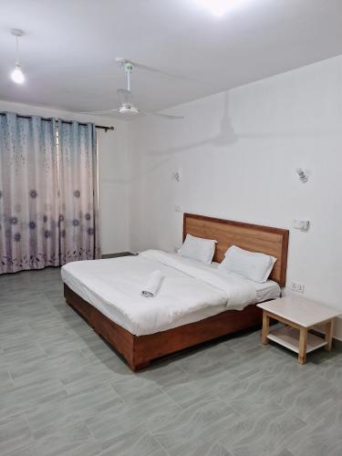 a bedroom with a large bed and a table at Jade luxury apartments in Galu