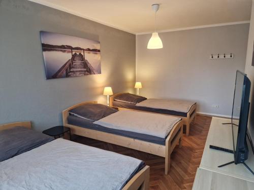 a room with two beds and a tv in it at Business Apartments Netzeband in Netzeband