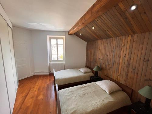 zwei Betten in einem Zimmer mit Holzwänden in der Unterkunft Appartement centre-ville très spacieux avec 4 chambres in La Tour-du-Pin