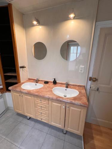 ein Badezimmer mit zwei Waschbecken und einem großen Spiegel in der Unterkunft Appartement centre-ville très spacieux avec 4 chambres in La Tour-du-Pin