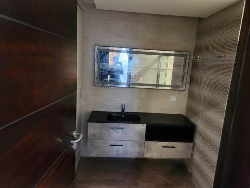 baño pequeño con lavabo y ventana en Elysium Service Apartment en Islamabad