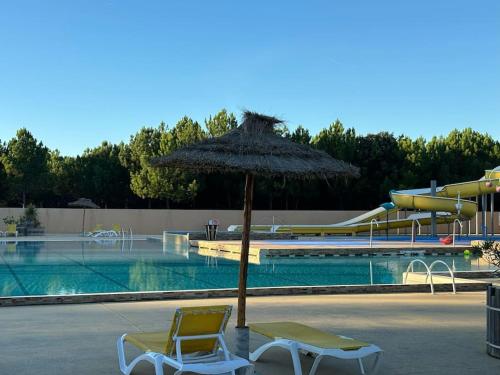 deux chaises et un parasol à côté d'une piscine dans l'établissement G02 Mobil-home gamme prestige aux Oyats 4 étoiles, à Seignosse