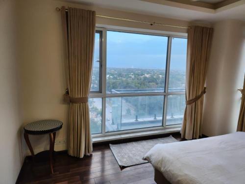 a bedroom with a large window with a view at Elysium Service Apartment in Islamabad