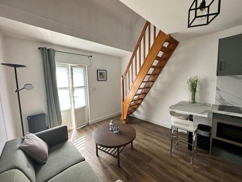 a living room with a couch and a piano at Appartement Cosy in Sainghin-en-Mélantois
