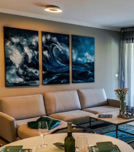 a living room with a couch and paintings on the wall at Luxe apartment Del Mare in Podstrana