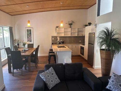 a living room and kitchen with a couch and a table at Sun Set Satinay Executive Villa 615 at Kingfisher Bay Fraser Island in Kingfisher Bay