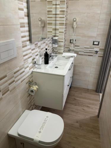 a bathroom with a white toilet and a sink at Scilla Resort in Scilla