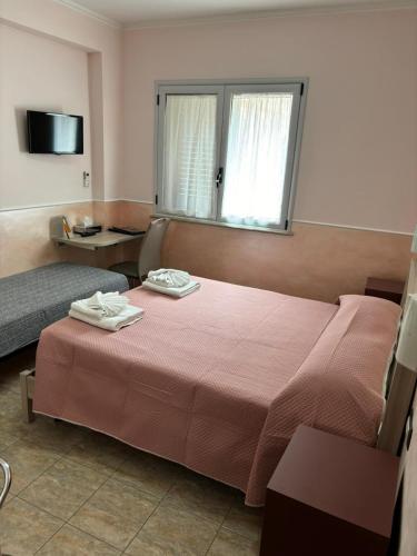 a hotel room with a bed and a window at Scilla Resort in Scilla