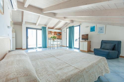 a large bedroom with a large bed and a blue chair at Residence Ascot in Cattolica