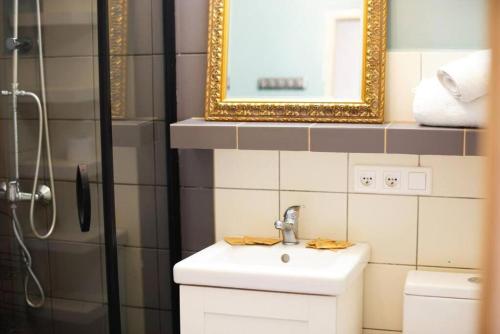 a bathroom with a sink and a shower with a mirror at Stanislawa Augusta by P&J Apartments in Warsaw