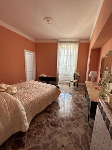 a bedroom with orange walls and a bed and a table at La Casa di Ilde Maison de charme et d art in Morcone