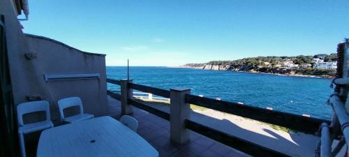d'une table et de chaises sur un balcon donnant sur l'eau. dans l'établissement Maison familiale vue et accès direct à la mer, à Sanary-sur-Mer