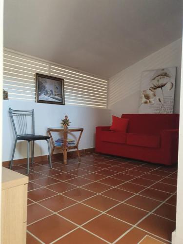 a living room with a red couch and a table at Villa con vista mare in Stalettì