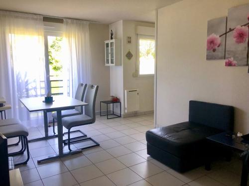 a living room with a table and a couch at Appartement au calme nature et centre ville in Quimper