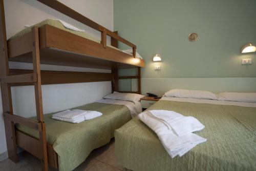 1 dormitorio con 2 literas y toallas. en Hotel Odeon, en Rímini